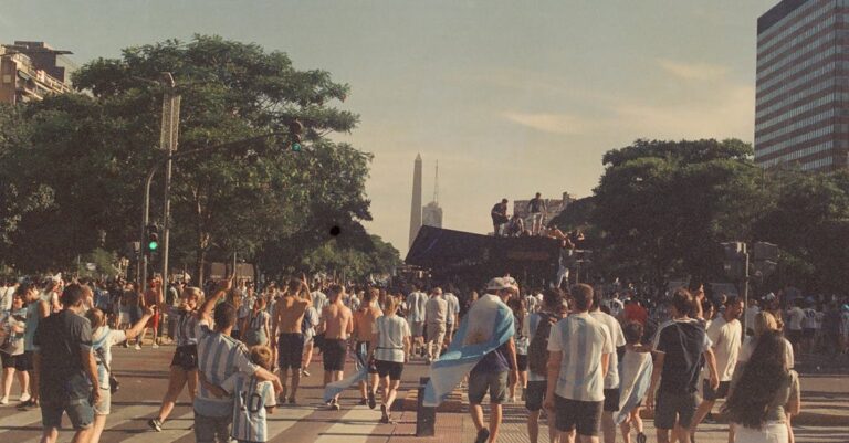 Argentinian football fans celebrate on a bustling street in Buenos Aires, embracing the World Cup victory.