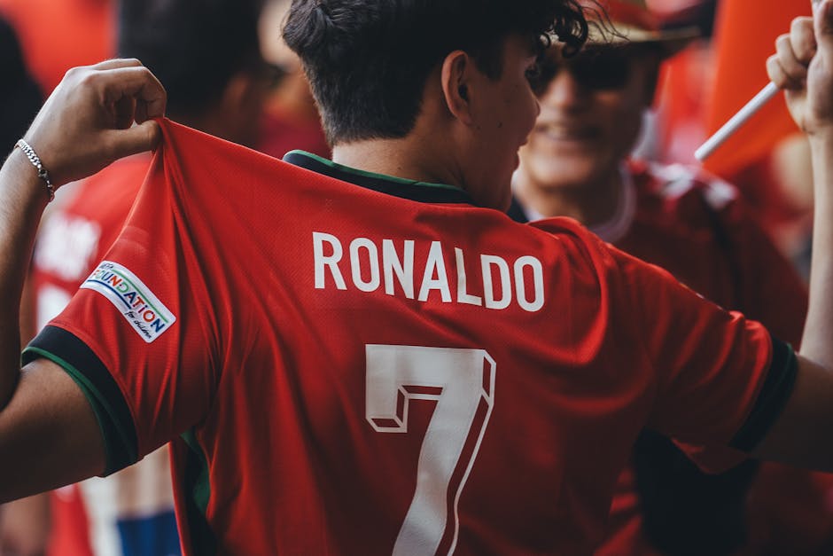 A passionate soccer fan wearing a Ronaldo jersey celebrates at a sports event.
